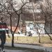 a man riding a skateboard down a sidewalk next to a park