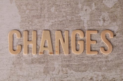 Wooden letters arranged to form 'Changes' on a textured, rustic surface.