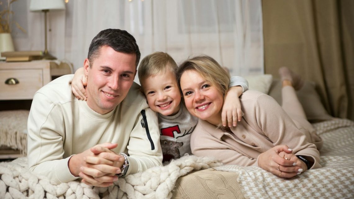 a man and woman with a couple of children on a bed